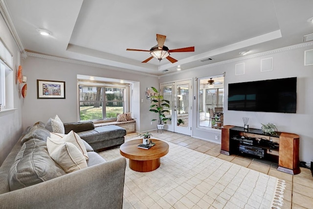 living room featuring light tile patterned floors, a raised ceiling, and ornamental molding