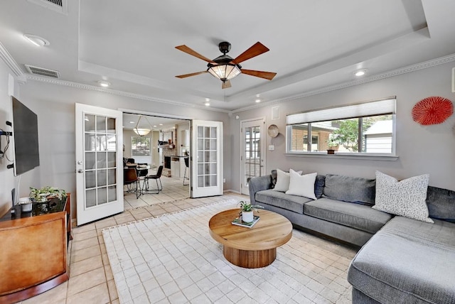 living room featuring visible vents, ornamental molding, light tile patterned floors, french doors, and a raised ceiling