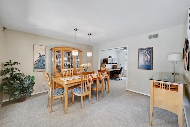 dining area featuring light carpet, visible vents, a ceiling fan, and baseboards