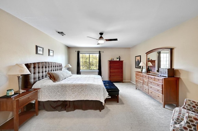 bedroom with visible vents, light colored carpet, and a ceiling fan