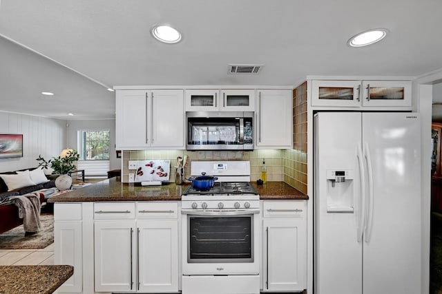 kitchen with visible vents, white appliances, white cabinets, and decorative backsplash