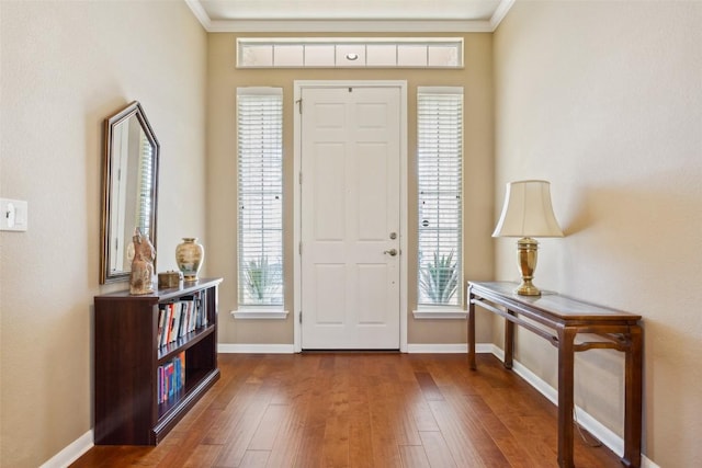 entrance foyer featuring baseboards, crown molding, and dark wood-type flooring