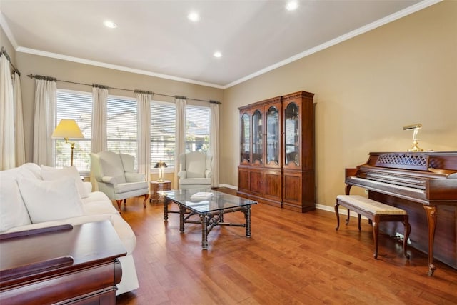 living room with recessed lighting, ornamental molding, baseboards, and wood finished floors