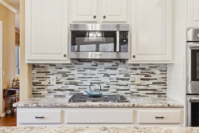 kitchen with white cabinetry, tasteful backsplash, and appliances with stainless steel finishes