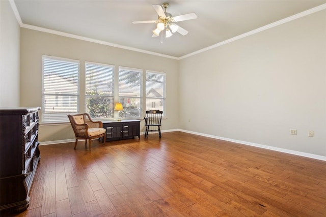 sitting room with a ceiling fan, crown molding, baseboards, and dark wood-style flooring