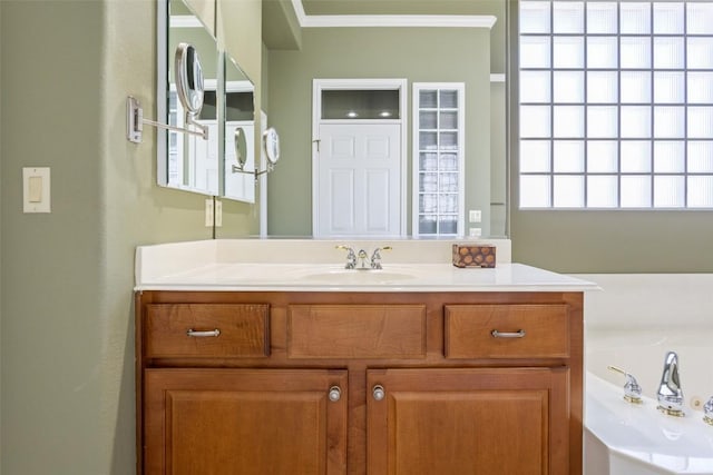 bathroom with vanity, crown molding, and a bath