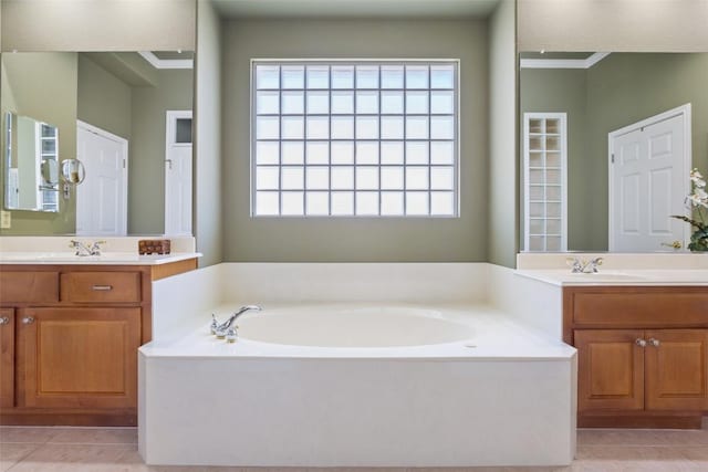 bathroom with two vanities, tile patterned floors, a bath, and a sink