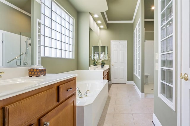 bathroom featuring tile patterned flooring, ornamental molding, a stall shower, a bath, and a sink