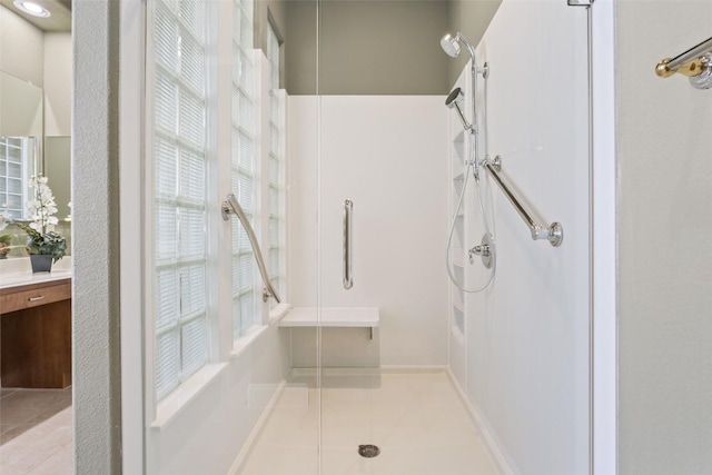 bathroom with tile patterned floors, a stall shower, and vanity