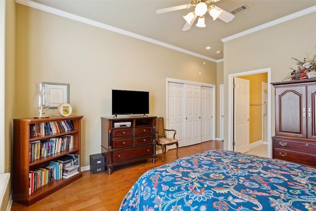 bedroom featuring visible vents, crown molding, baseboards, light wood-style flooring, and a closet