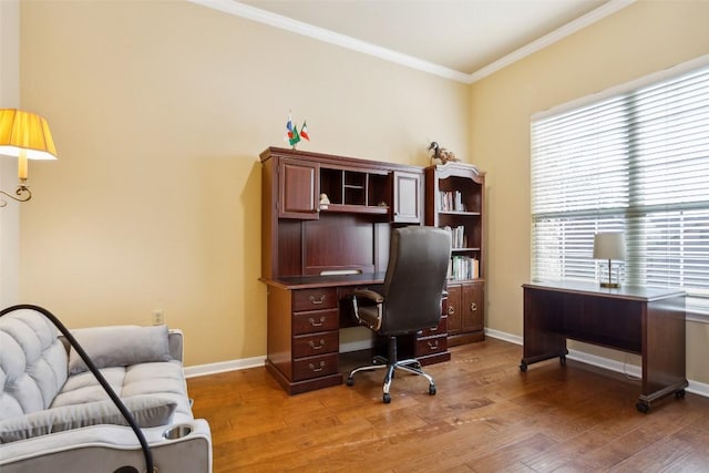 office area with light wood-style flooring, crown molding, and baseboards