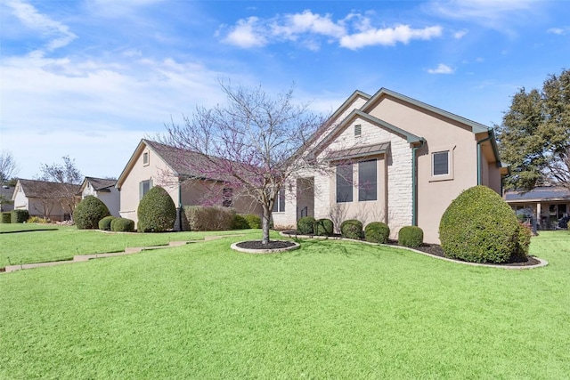 view of front of home with stone siding, stucco siding, and a front yard