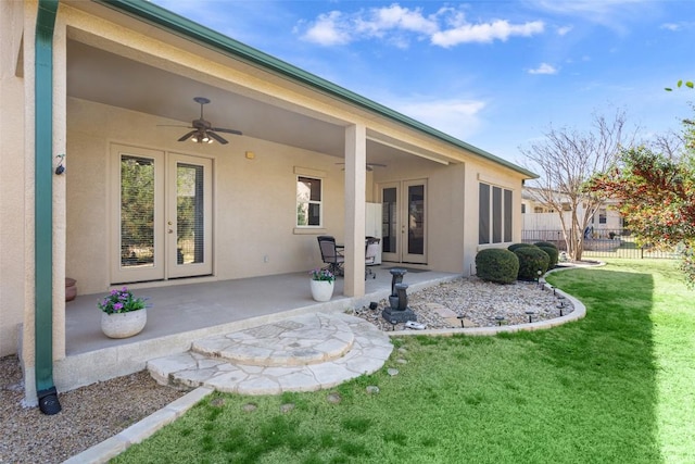 rear view of house with a patio area, french doors, fence, and stucco siding