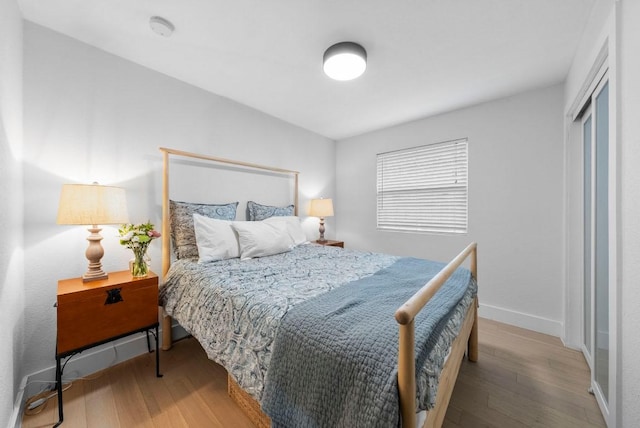 bedroom with baseboards and wood finished floors