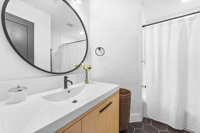 bathroom with tile patterned floors, visible vents, shower / tub combo with curtain, and vanity