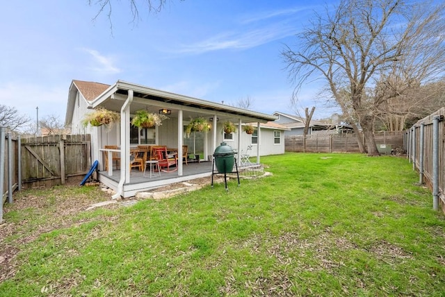 rear view of house with a fenced backyard, a patio, and a yard