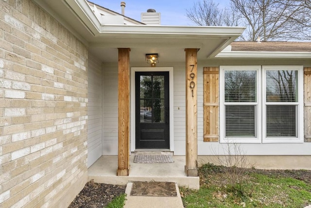 view of exterior entry with a chimney