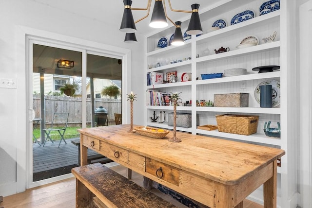 dining room with built in shelves and light wood-style flooring