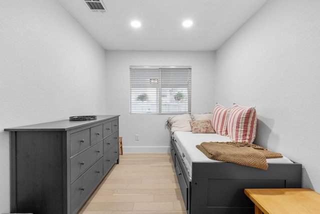 bedroom featuring light wood finished floors, visible vents, recessed lighting, and baseboards