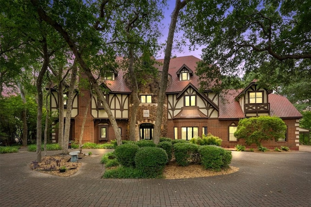 tudor house featuring brick siding and stucco siding