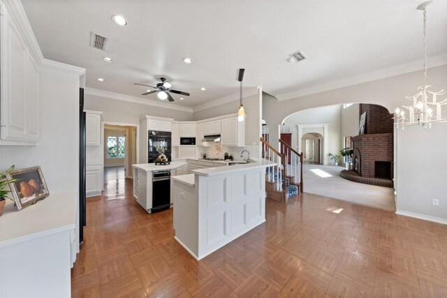 kitchen featuring arched walkways, visible vents, a brick fireplace, and dobule oven black