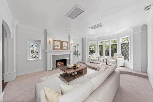 living area featuring visible vents, baseboards, a premium fireplace, ornamental molding, and decorative columns