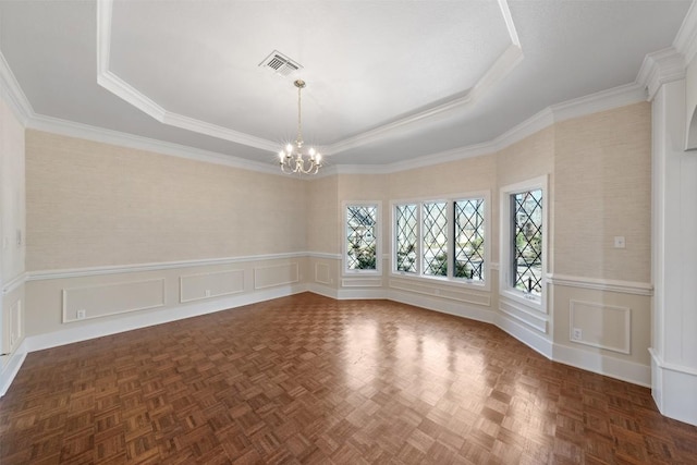 unfurnished room with a chandelier, visible vents, a tray ceiling, and a wainscoted wall