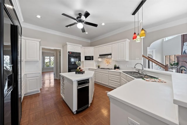 kitchen with a sink, black appliances, white cabinets, and crown molding