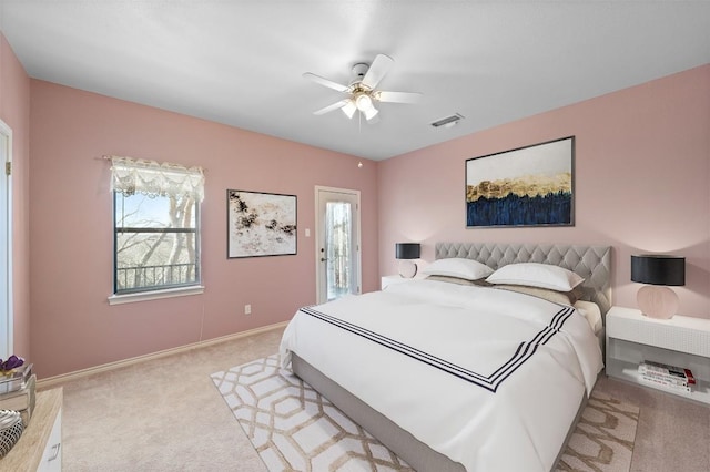 bedroom featuring visible vents, light colored carpet, baseboards, and ceiling fan