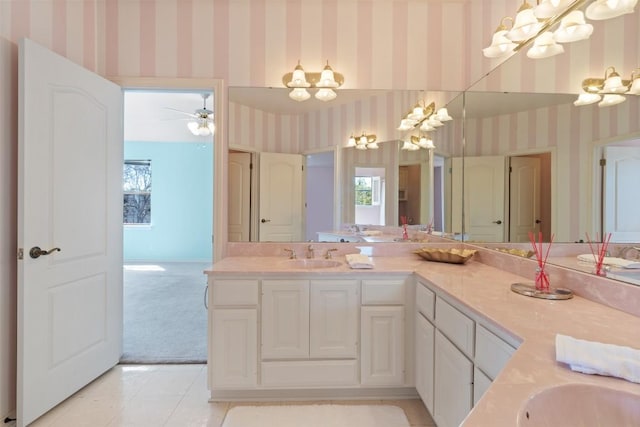 bathroom with double vanity, tile patterned floors, wallpapered walls, and a sink