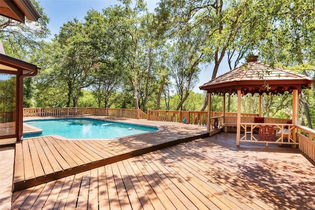 view of swimming pool featuring a gazebo, a fenced in pool, and a wooden deck