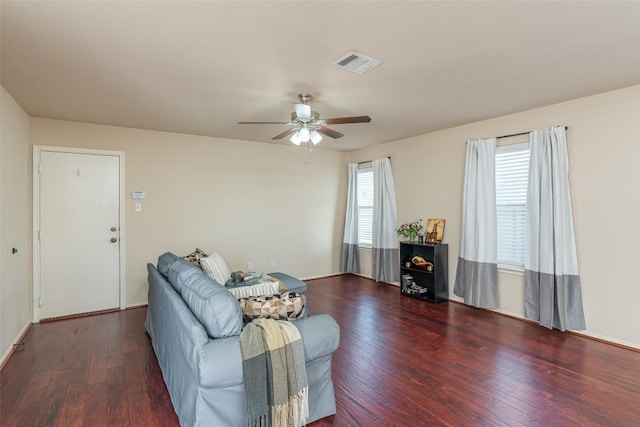 living area with a ceiling fan, wood finished floors, and visible vents