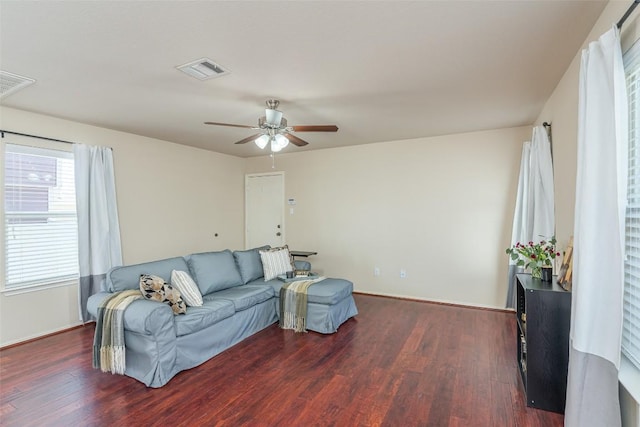 living area featuring dark wood-type flooring, a ceiling fan, and visible vents