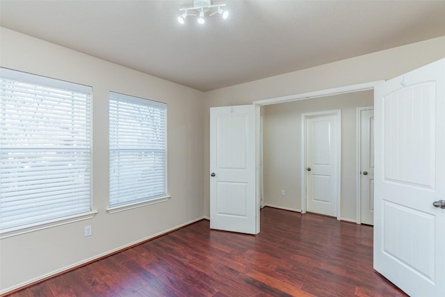 unfurnished bedroom with baseboards and wood finished floors