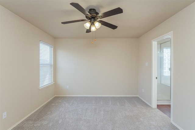 carpeted empty room featuring ceiling fan and baseboards