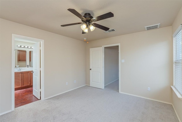 unfurnished bedroom featuring visible vents, baseboards, carpet, and a sink