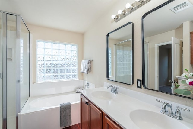 bathroom featuring a stall shower, a bath, visible vents, and a sink