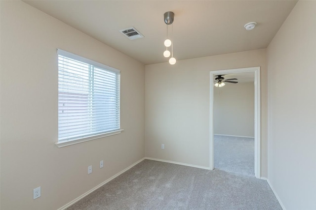 carpeted empty room with visible vents and baseboards