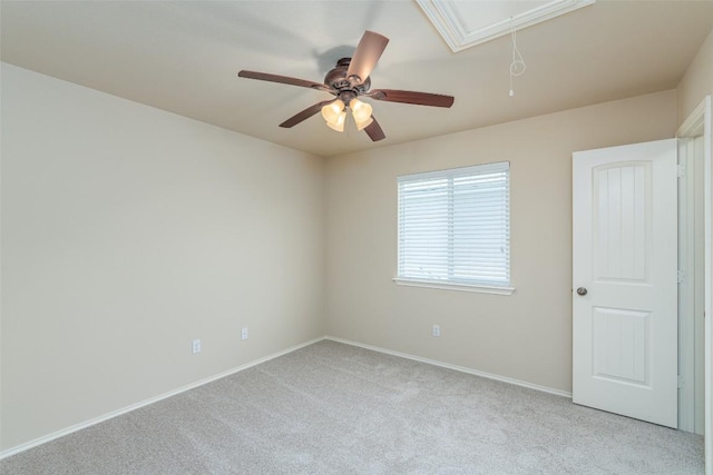 carpeted spare room with baseboards and attic access