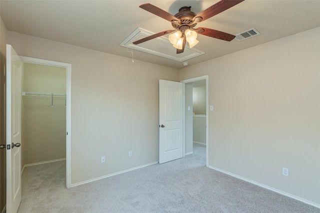 unfurnished bedroom featuring visible vents, light carpet, attic access, and a spacious closet