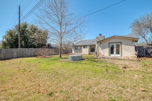 view of yard with french doors and a fenced backyard