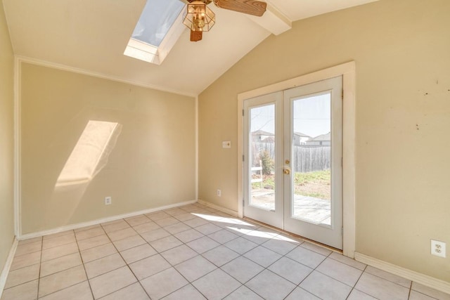 unfurnished room featuring light tile patterned floors, a ceiling fan, baseboards, vaulted ceiling with skylight, and french doors