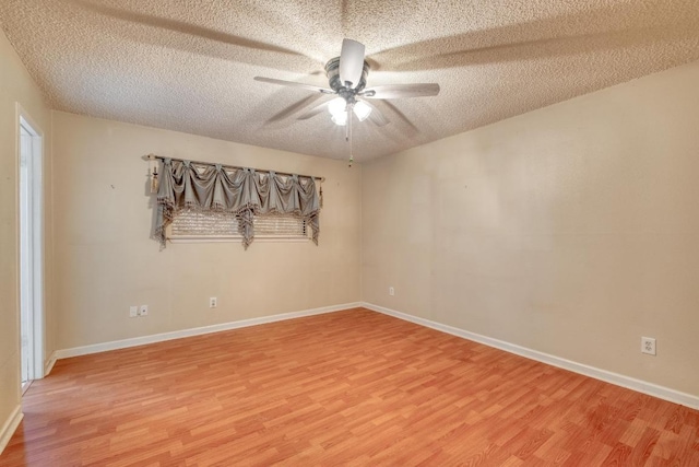 unfurnished room featuring ceiling fan, a textured ceiling, light wood-type flooring, and baseboards