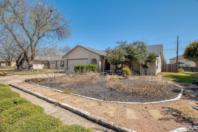 view of front facade featuring stone siding, an attached garage, and fence