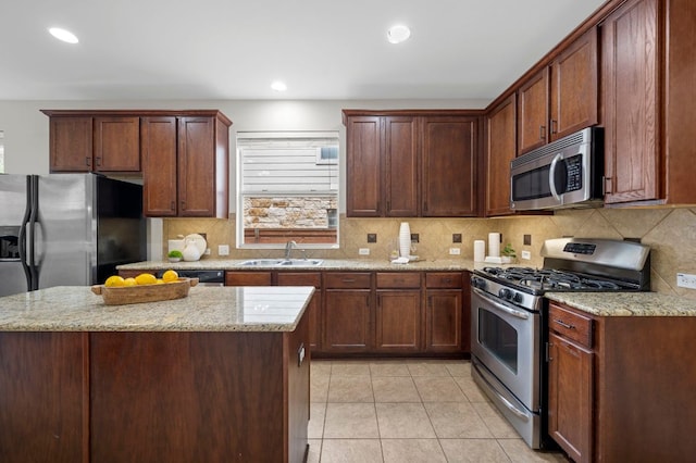 kitchen with a sink, light tile patterned floors, tasteful backsplash, and stainless steel appliances