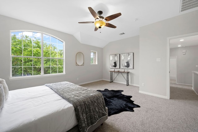 bedroom with visible vents, light colored carpet, baseboards, and vaulted ceiling