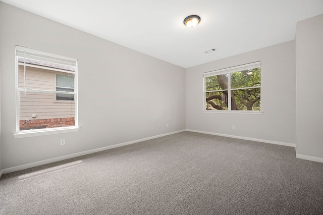 carpeted empty room featuring visible vents and baseboards