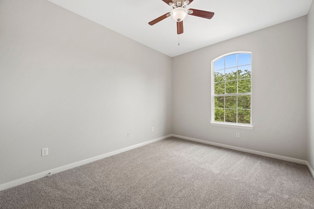 spare room featuring carpet, baseboards, and ceiling fan