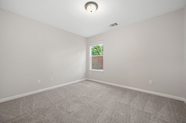 carpeted empty room featuring visible vents and baseboards