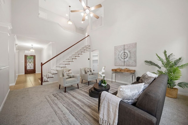 living room with a ceiling fan, stairway, carpet, a high ceiling, and baseboards